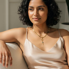 Charger l'image dans la galerie, Woman wearing a gold necklace sitting on a couch.