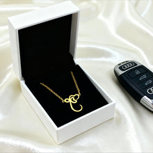 Load image into Gallery viewer, Gold necklace in a white box with an Audi key fob on a white fabric background