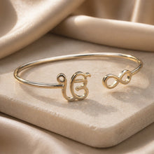 Charger l'image dans la galerie, Gold bracelet with unique design on a beige fabric background
