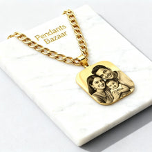 Charger l'image dans la galerie, Gold necklace with a pendant featuring an engraved image of a family on a white marble surface.
