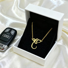 Load image into Gallery viewer, Gold necklace in an open box with a car key fob on a white fabric background
